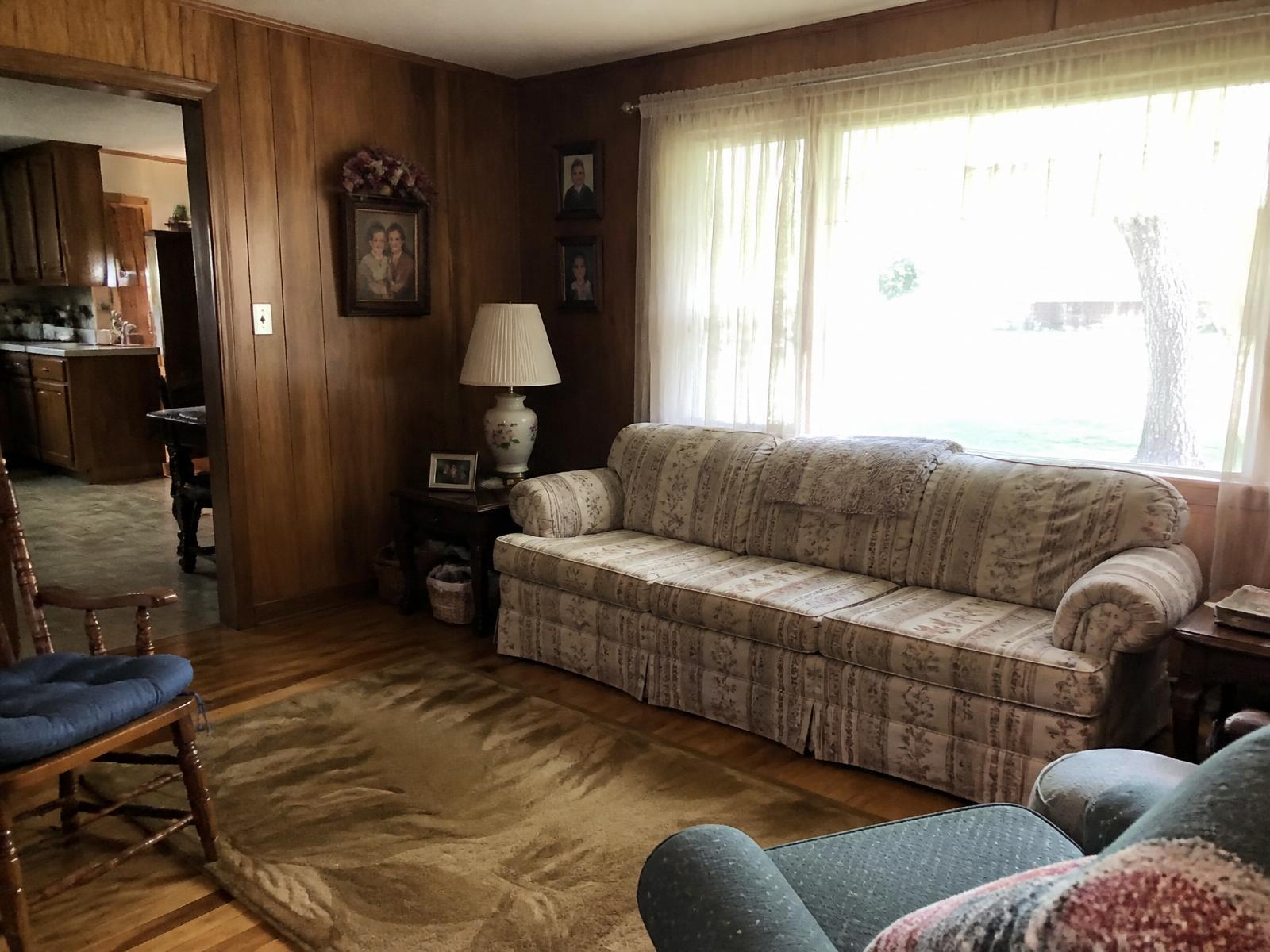 A warm, lived in living room in an older East Tennessee home with natural light coming through the window.